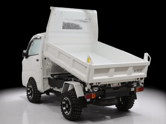 Studio shot of Daihatsu Hijet HD Dump left rear with bed raised