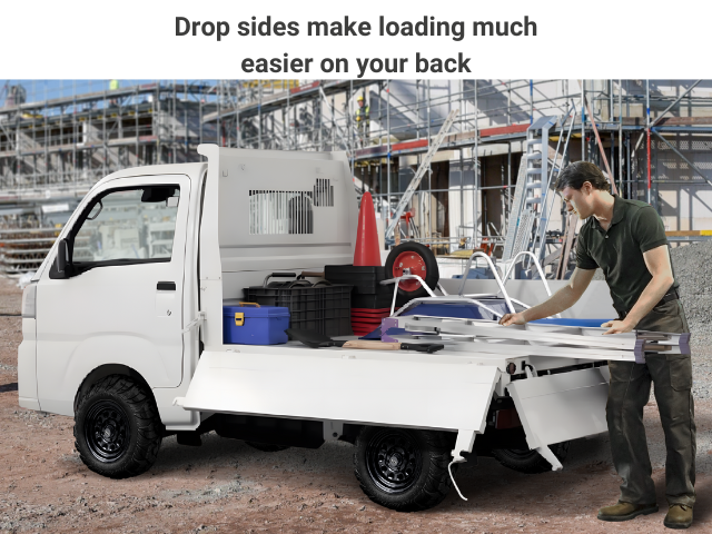 Man loading Daihatsu HD Dump Japanese mini truck with construction gear showcasing drop sides