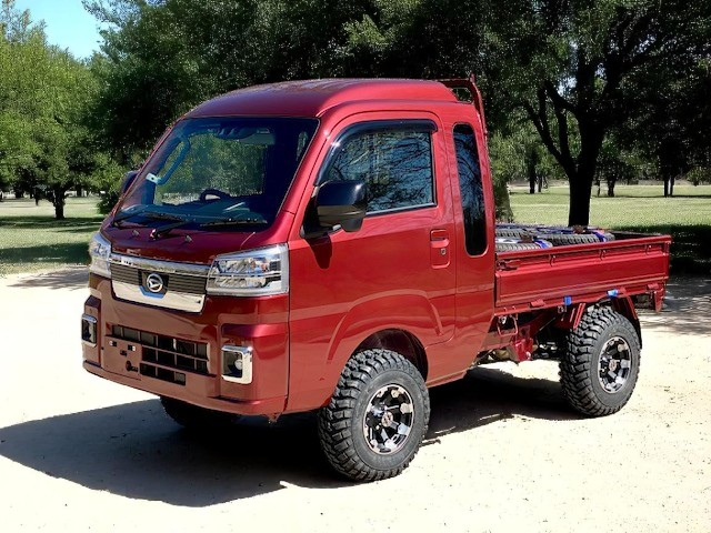 Daihatsu Hijet Jumbo red model on sand under trees