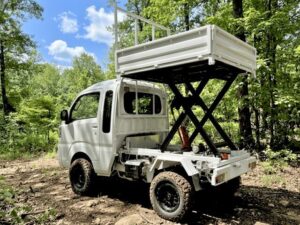 Daihatsu Hijet Jumbo model with Scissor Dump 4×4 Japanese mini truck in white seen from the left rear with the bed raised as a platform Daihatsu Hijet Jumbo model with Scissor Dump 4x4 Japanese mini truck in white seen from the left rear with the bed raised as a platform