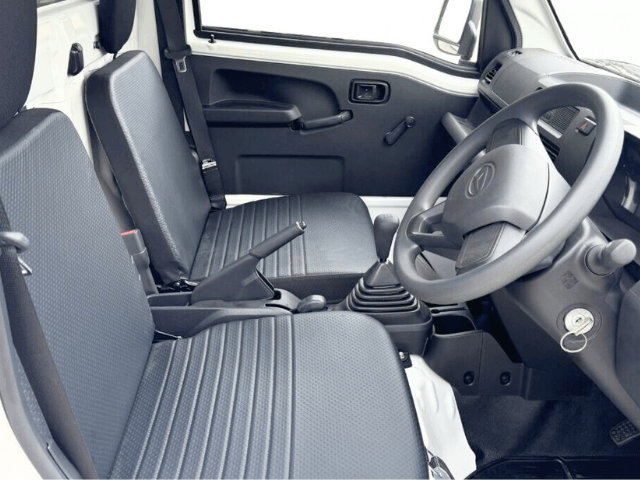 Daihatsu Hijet HD Dump manual model with electro-hydraulic bed in field showing seats and interior